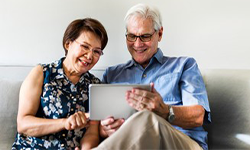 two aging people looking at an ipad