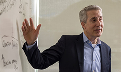 man talking in front of a white board