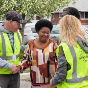 A man and a woman helping another woman