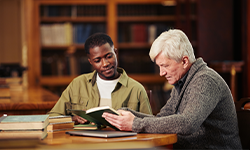 elderly man studying in a library