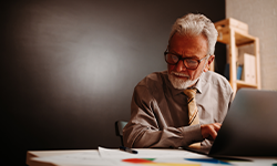elderly man working on a laptop