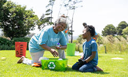 elderly african-american woman helping a kid pick up trash