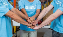 people in circle with hands in center